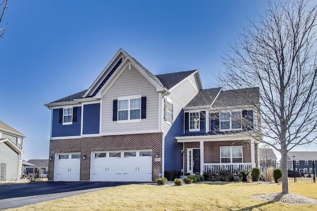 view of front facade featuring brick siding, a front lawn, a porch, a garage, and driveway