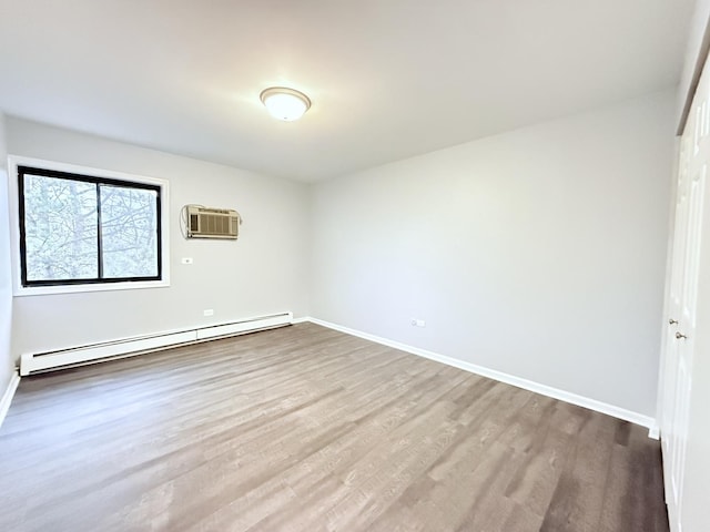 unfurnished bedroom featuring a wall mounted air conditioner, baseboards, baseboard heating, and wood finished floors