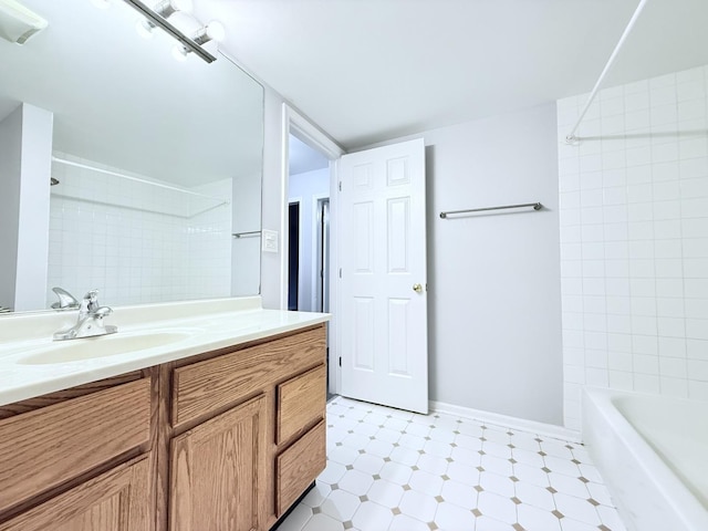 bathroom featuring tile patterned floors, shower / bath combination, baseboards, and vanity