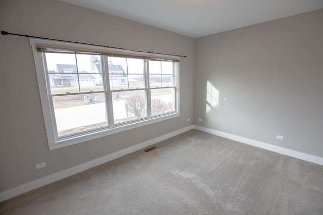 carpeted empty room with baseboards and visible vents