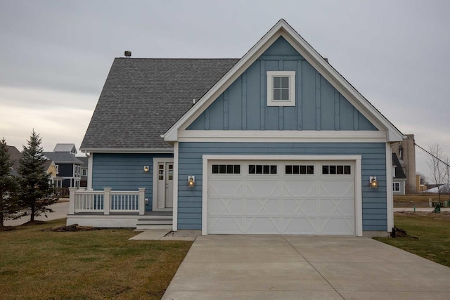 view of front of house with driveway, an attached garage, a chimney, a front lawn, and board and batten siding