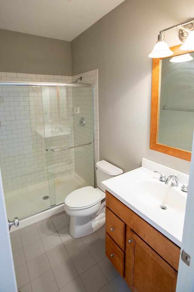 full bath with vanity, a shower stall, toilet, and tile patterned floors