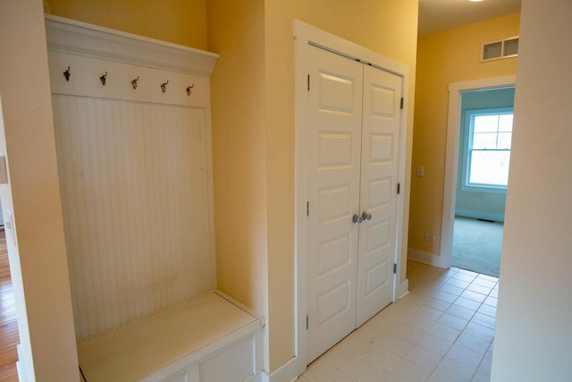 mudroom featuring light tile patterned floors, visible vents, and baseboards