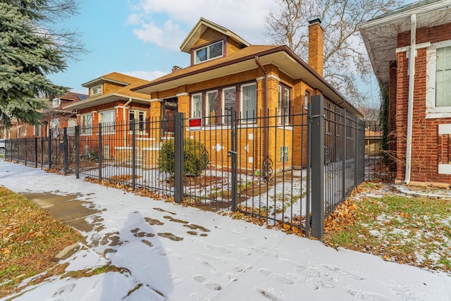 view of front of home with a fenced front yard, a chimney, and brick siding