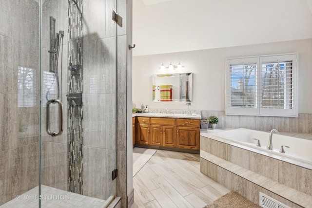 full bathroom with vanity, visible vents, a garden tub, and a shower stall