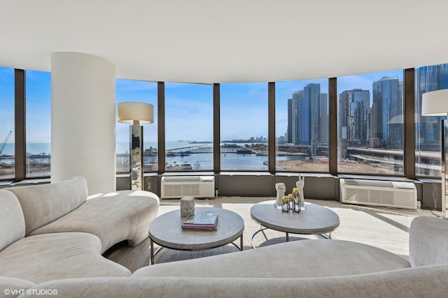 living room with expansive windows, a water view, and plenty of natural light