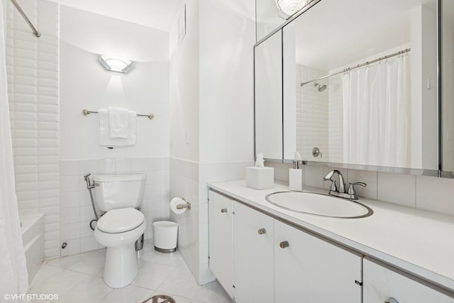 full bathroom featuring tile patterned flooring, a wainscoted wall, toilet, vanity, and tile walls