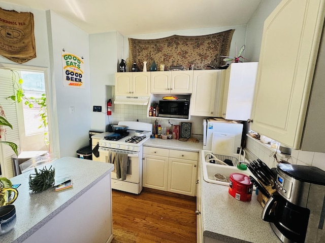 944 W 18th St, Chicago, IL 60608 - kitchen with white range with gas stovetop, under cabinet range hood, decorative backsplash, and light countertops