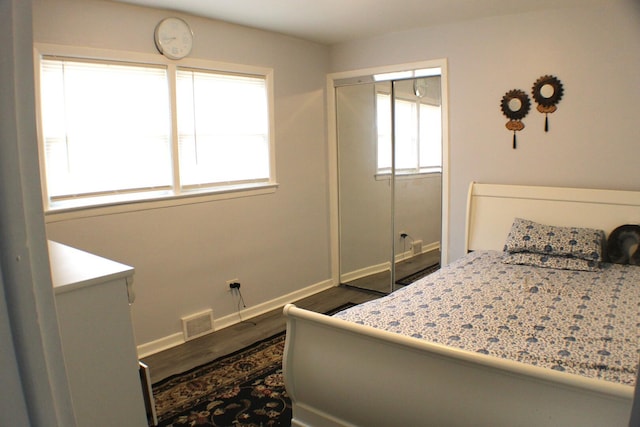 bedroom featuring visible vents, baseboards, a closet, and dark wood-style floors