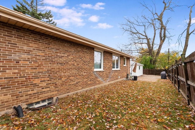 view of side of home featuring brick siding and a fenced backyard