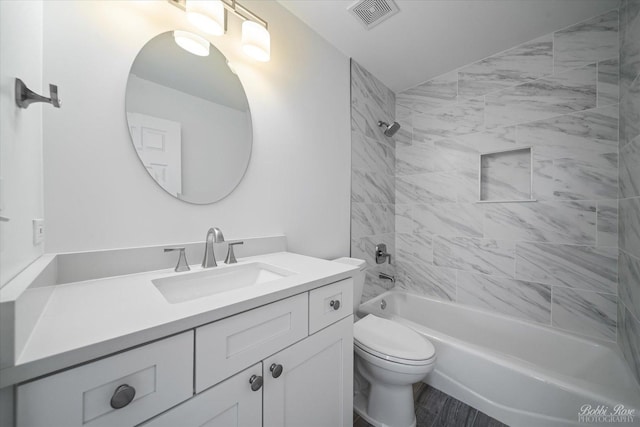 bathroom featuring visible vents, toilet, wood finished floors, vanity, and  shower combination