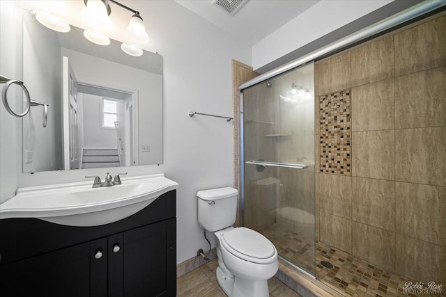 bathroom with visible vents, vanity, toilet, and a shower stall