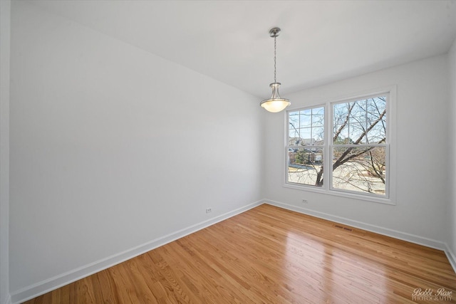 unfurnished room featuring visible vents, baseboards, and light wood finished floors