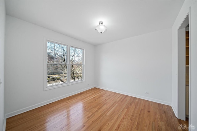 unfurnished room featuring light wood-type flooring and baseboards