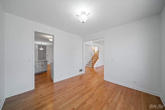 6005 River Bend Dr, Lisle, IL 60532 - spare room with stairway, baseboards, and light wood-style flooring