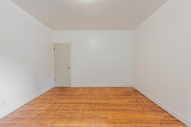 spare room with light wood finished floors and baseboards