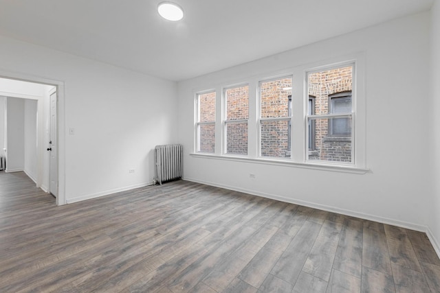 unfurnished room featuring baseboards, radiator, and dark wood-style floors