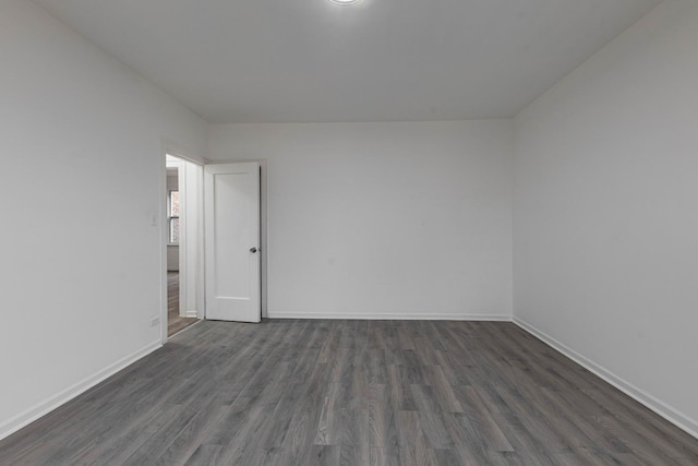 spare room with dark wood finished floors and baseboards