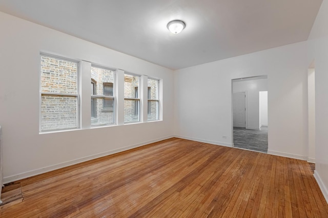 empty room with baseboards and light wood-style floors