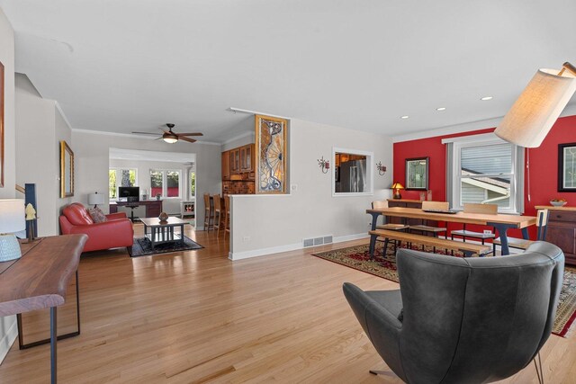 living room featuring wood finished floors, ceiling fan, recessed lighting, baseboards, and ornamental molding