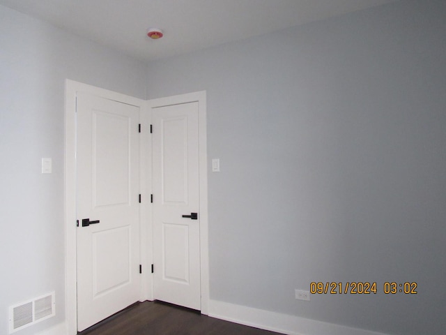 spare room featuring dark wood-style flooring, baseboards, and visible vents