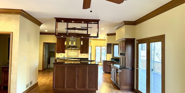 kitchen featuring dark countertops, a center island, ceiling fan, range hood, and dark wood-style flooring