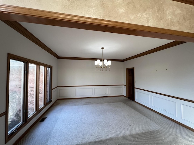 unfurnished room with visible vents, light colored carpet, an inviting chandelier, and ornamental molding