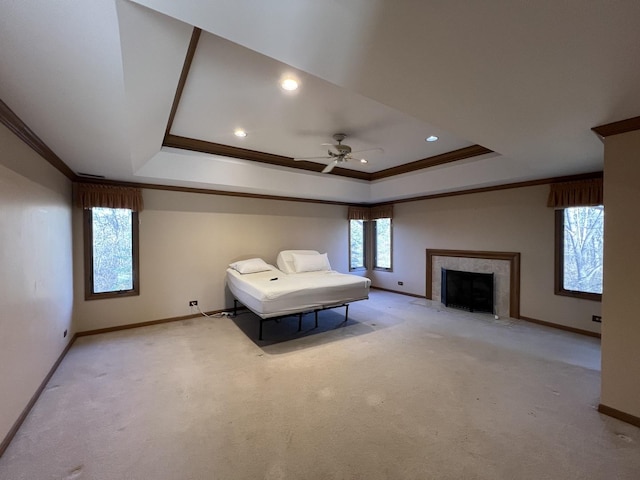 unfurnished bedroom with a raised ceiling, carpet flooring, crown molding, and baseboards