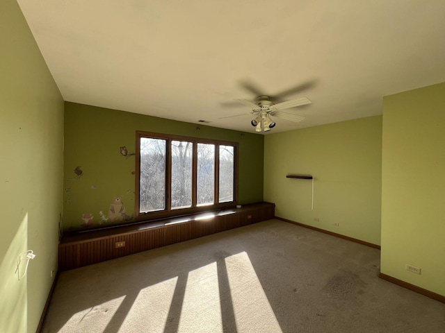 carpeted empty room featuring visible vents, baseboards, and a ceiling fan