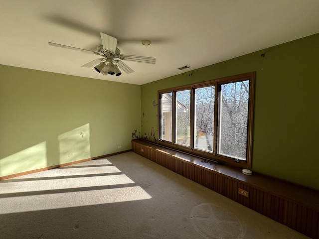 unfurnished room with visible vents, baseboards, ceiling fan, and carpet flooring