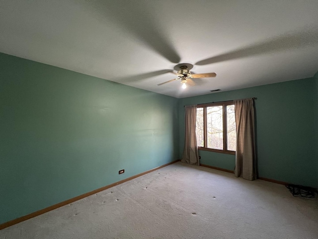 empty room with light colored carpet, baseboards, visible vents, and ceiling fan