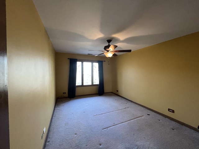 empty room with a ceiling fan, baseboards, and light carpet