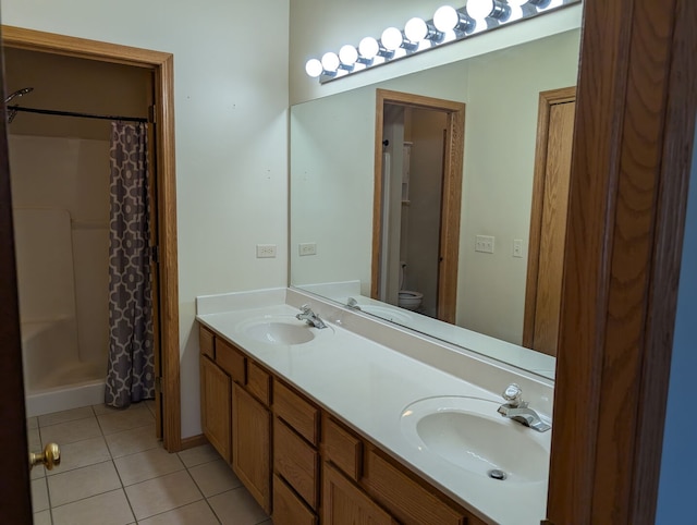 full bath featuring tile patterned flooring, double vanity, toilet, and a sink