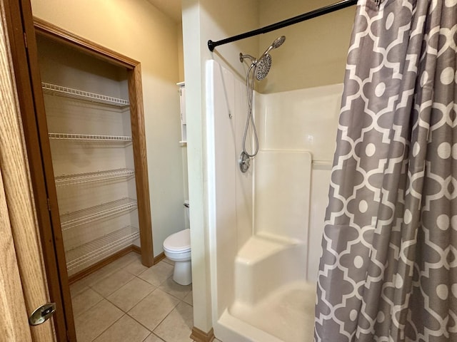 bathroom with tile patterned flooring, toilet, and a shower with shower curtain