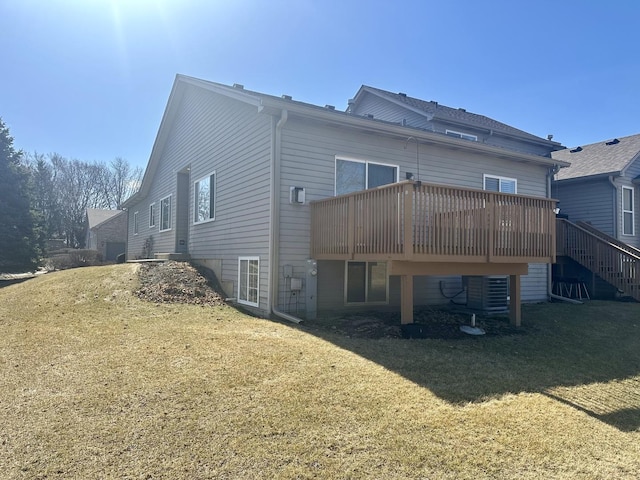 back of house featuring central air condition unit, a lawn, and a wooden deck