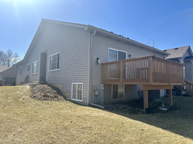 back of house with a deck and a yard