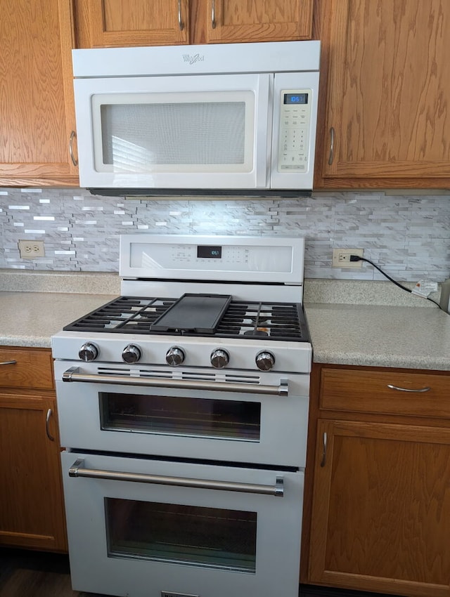 kitchen featuring white appliances, tasteful backsplash, and light countertops