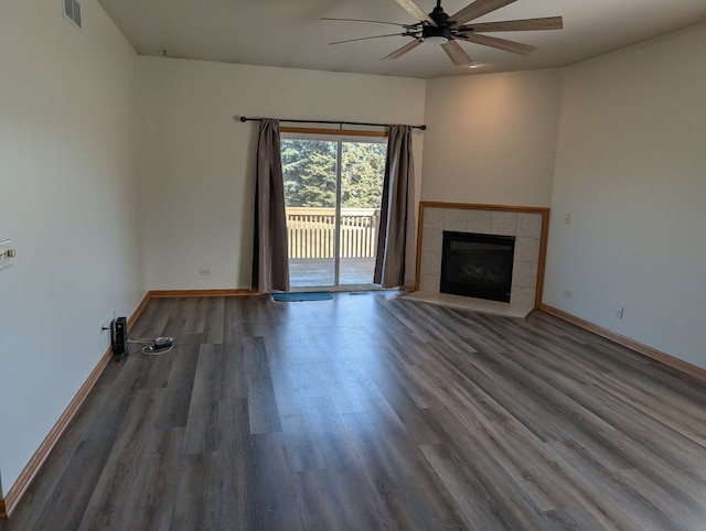 unfurnished living room with visible vents, wood finished floors, baseboards, ceiling fan, and a tile fireplace