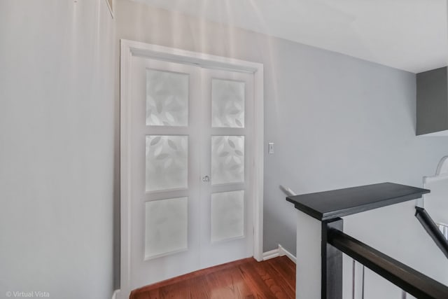 hallway featuring an upstairs landing, dark wood-style floors, and baseboards