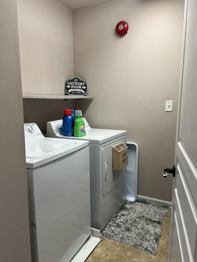 laundry room featuring baseboards, light tile patterned floors, laundry area, and washer and dryer