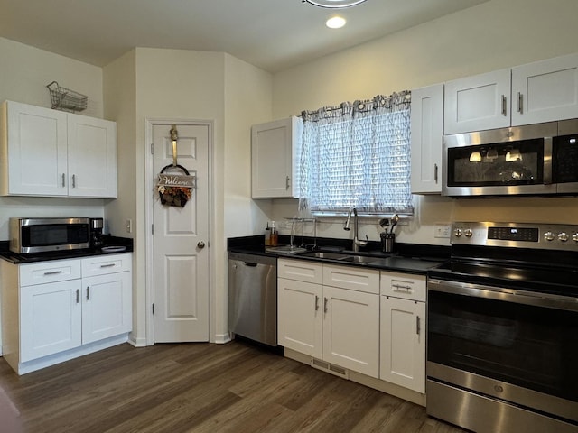 997 Regent Dr, Matteson, IL 60443 - kitchen with appliances with stainless steel finishes, a sink, dark wood-style flooring, dark countertops, and white cabinets