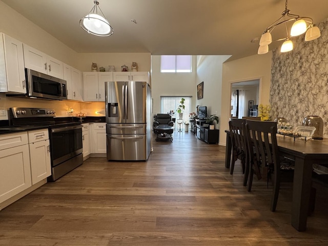 997 Regent Dr, Matteson, IL 60443 - kitchen featuring appliances with stainless steel finishes, dark countertops, dark wood finished floors, and white cabinets