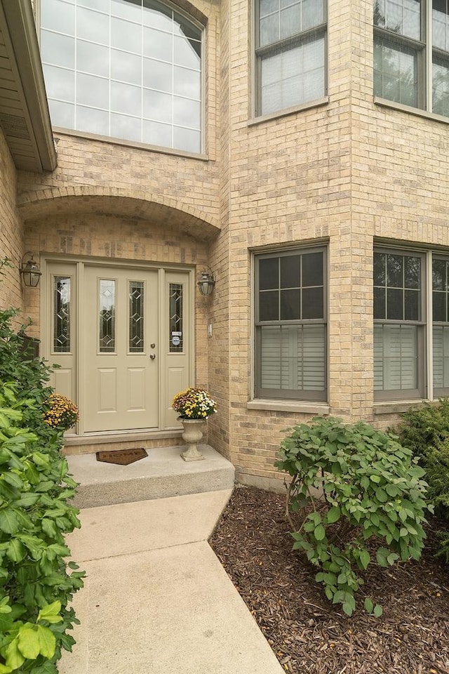 entrance to property featuring brick siding