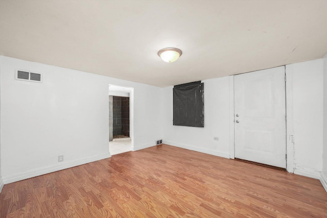 spare room featuring baseboards, visible vents, and light wood-type flooring