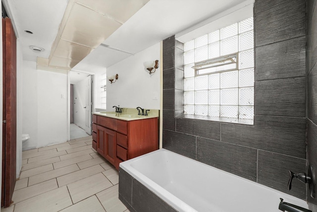 full bathroom featuring a bath, double vanity, toilet, and a sink