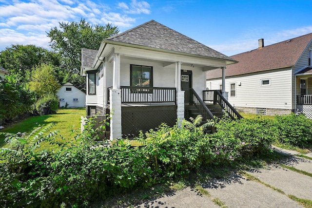 shotgun-style home featuring stairs, covered porch, and a shingled roof