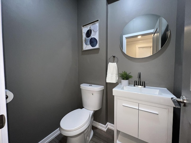 7223 S Paxton Ave, Chicago, IL 60649 - half bath with toilet, baseboards, vanity, and wood finished floors