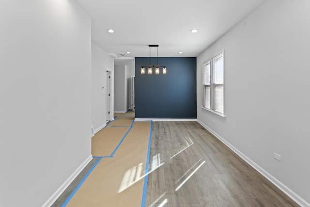 interior space featuring recessed lighting, baseboards, and wood finished floors