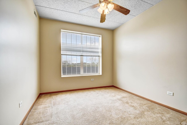 carpeted spare room with a ceiling fan, baseboards, and visible vents