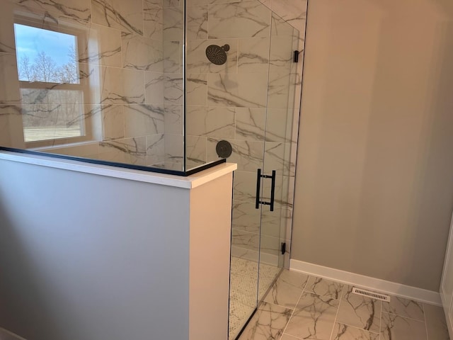 details with a marble finish shower, visible vents, and baseboards